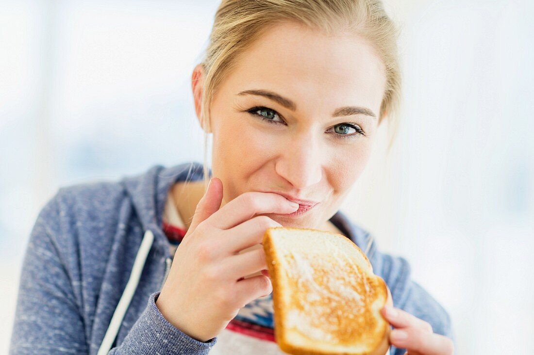 Junge Frau isst Toast