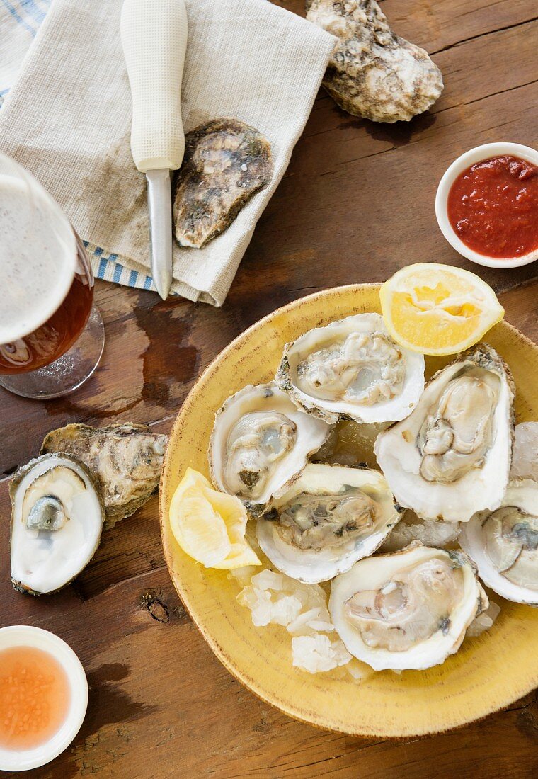 Oysters with lemons, dips and beer