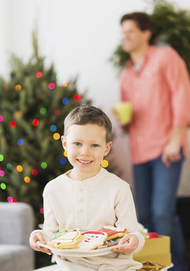 Junge hält Teller mit Weihnachtsgebäck