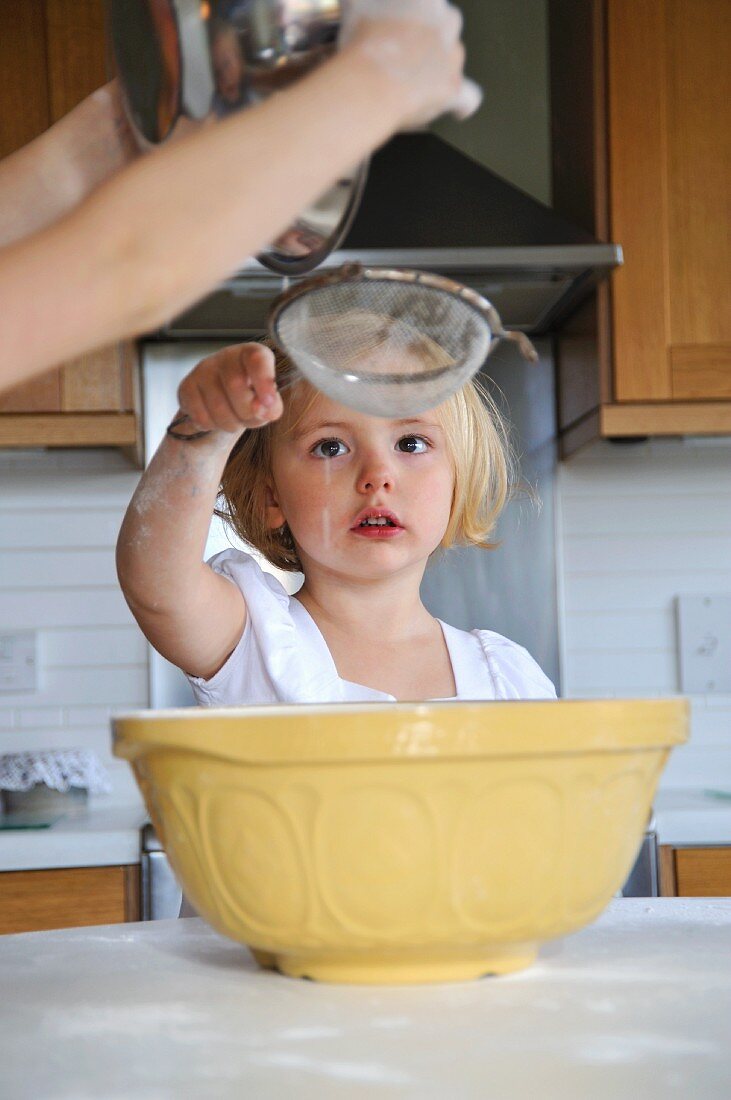 Kleines Mädchen hilft beim Backen in der Küche