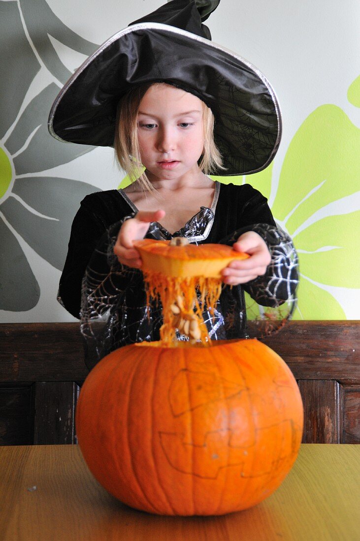 A girl in a Halloween costume with a pumpkin