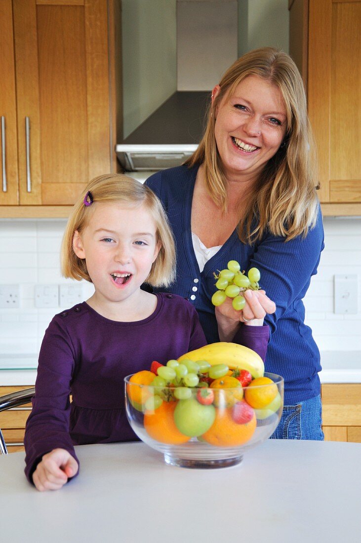 Mutter und Tochter mit Obstschale in der Küche