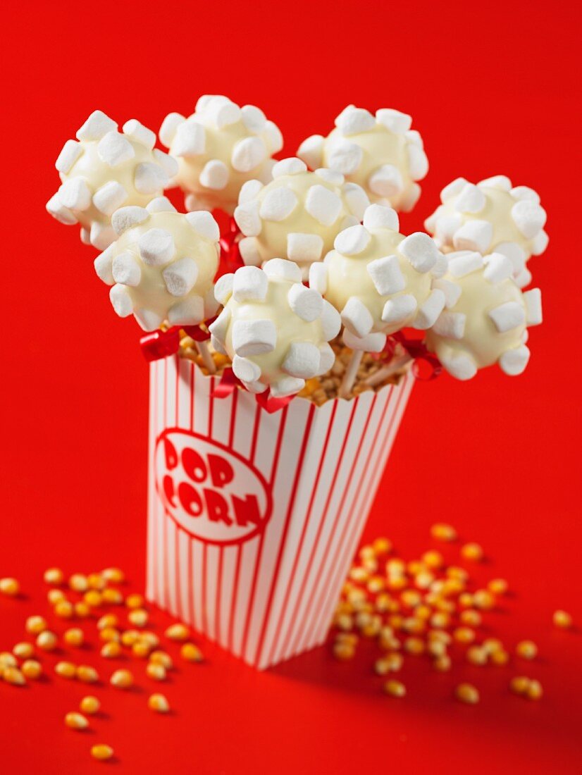 Cake pops decorated with marshmallows in a popcorn bucket