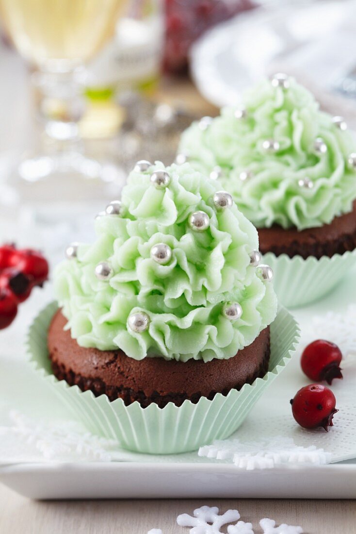 Christmas cupcakes decorated with mint-coloured cream and silver balls