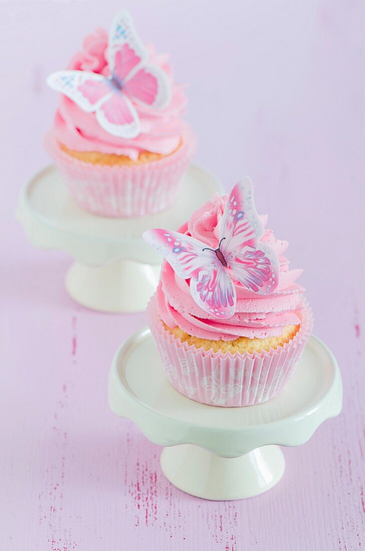 Romantische Cupcakes mit rosa Buttercreme und Schmetterling