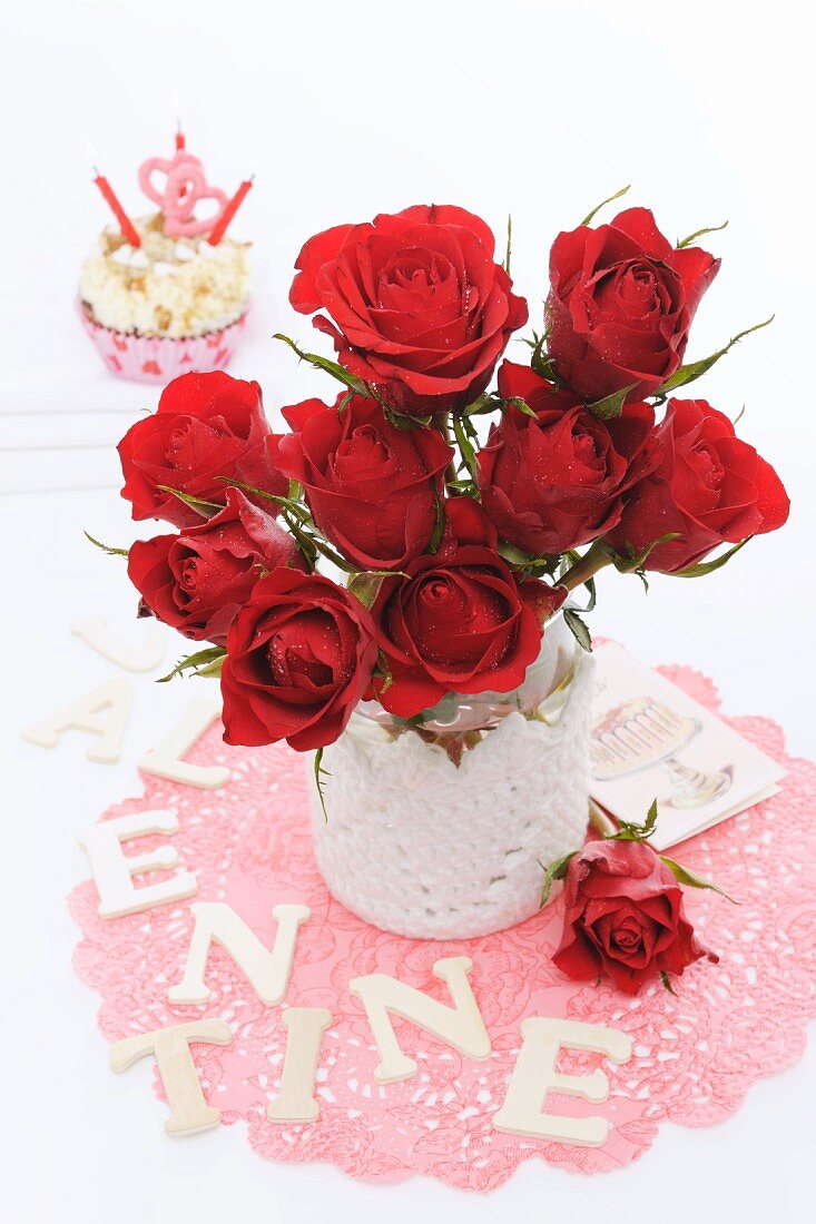 Cupcake und roter Rosenstrauss zum Valentinstag