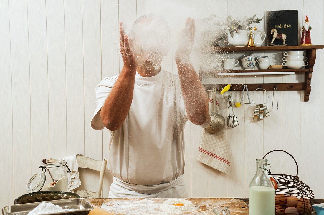 A confectioner sprinkling flour in the air