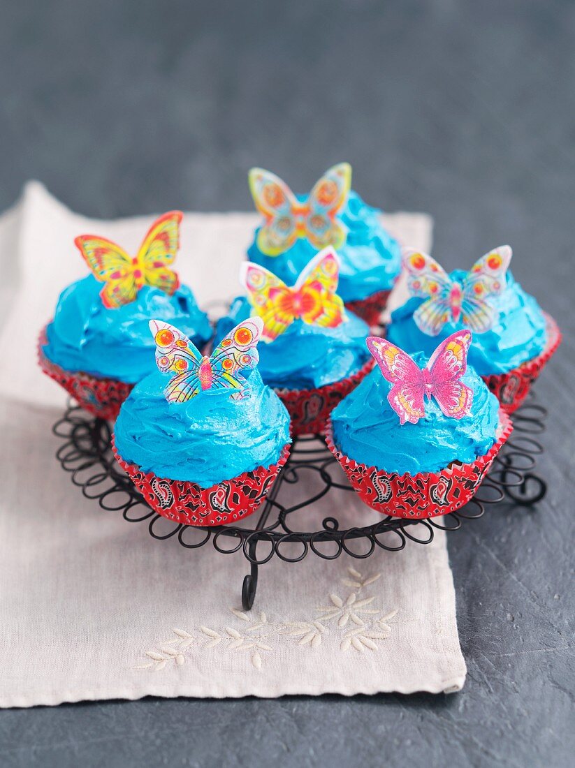 Cupcakes decorated with blue buttercream and butterflies