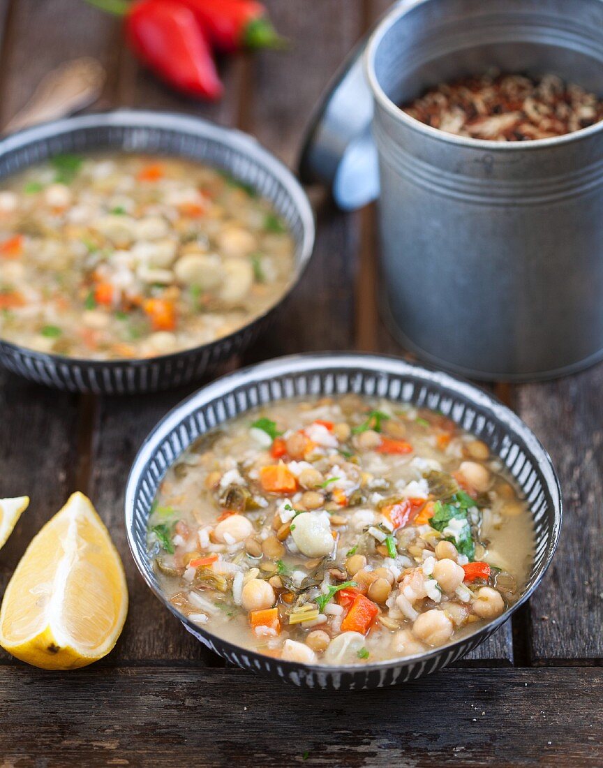 Suppe mit Linsen, Kichererbsen, weissen Bohnen, Möhren, Reis und Koriander in zwei Schälchen