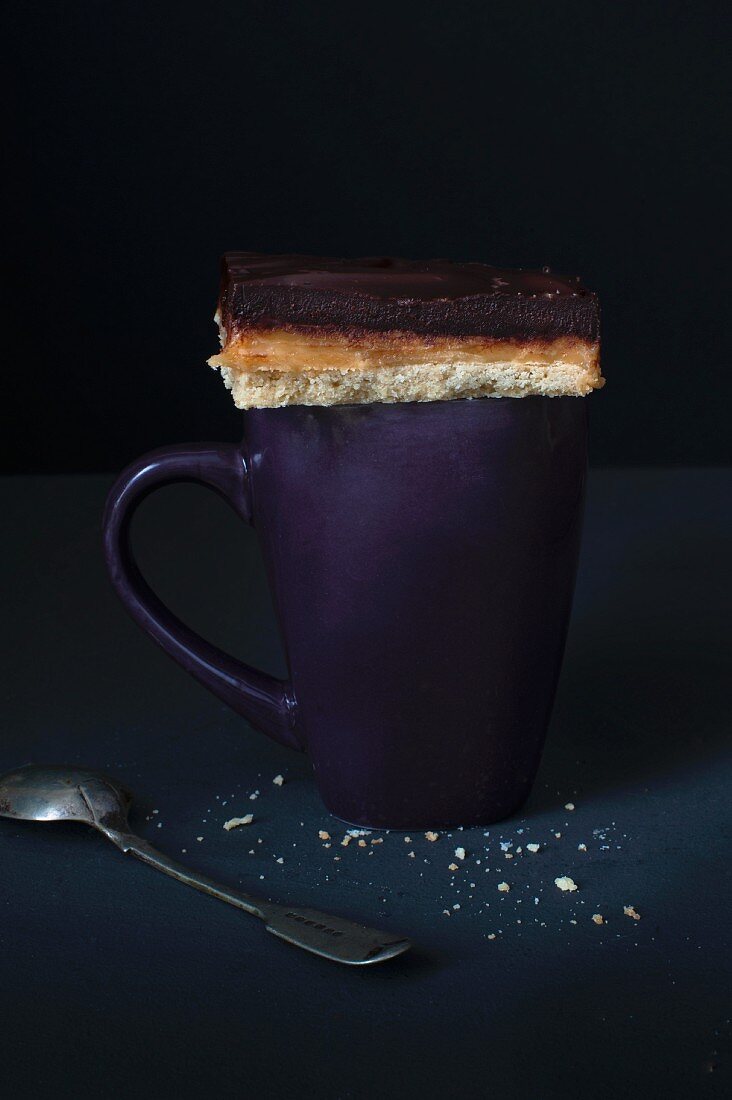 A piece of millionaires shortbread on a purple mug