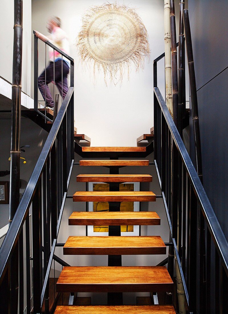 Staircase with wooden treads and metal balustrade; artwork on wall of landing