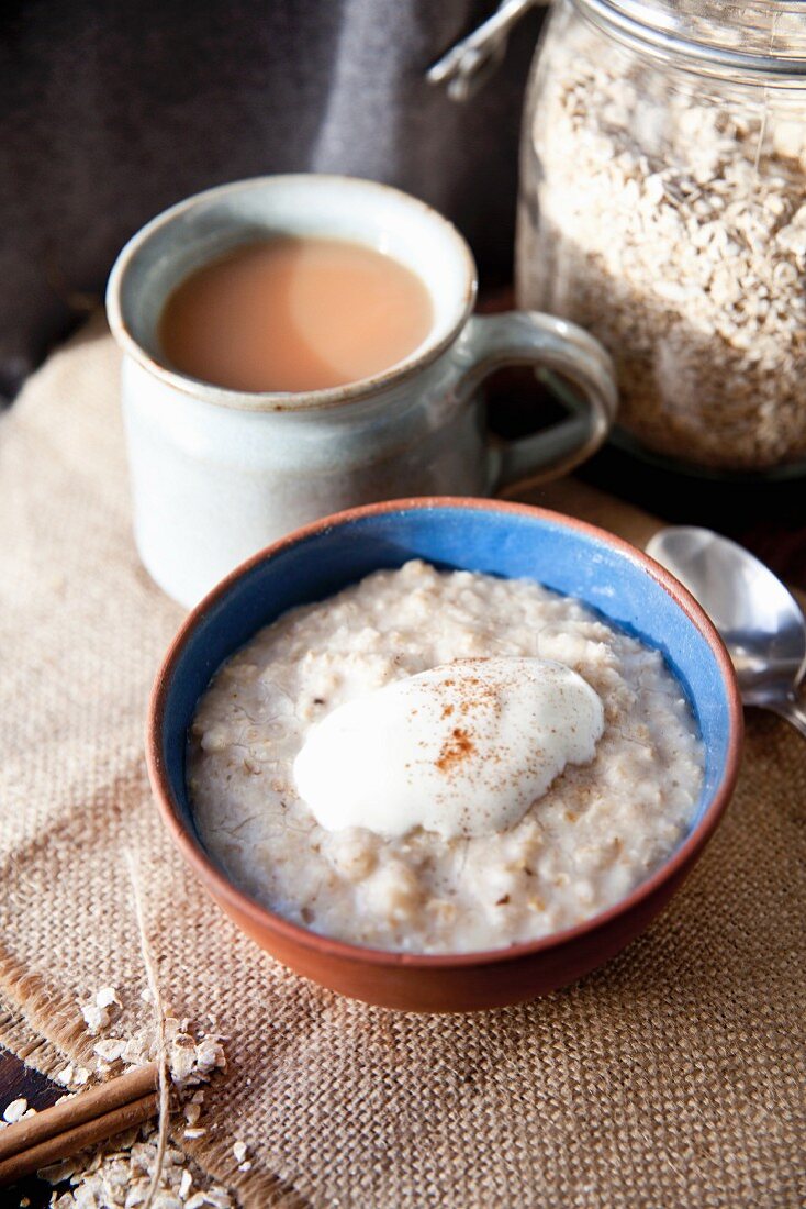 Porridge with yogurt and cinnamon served with a mug of tea
