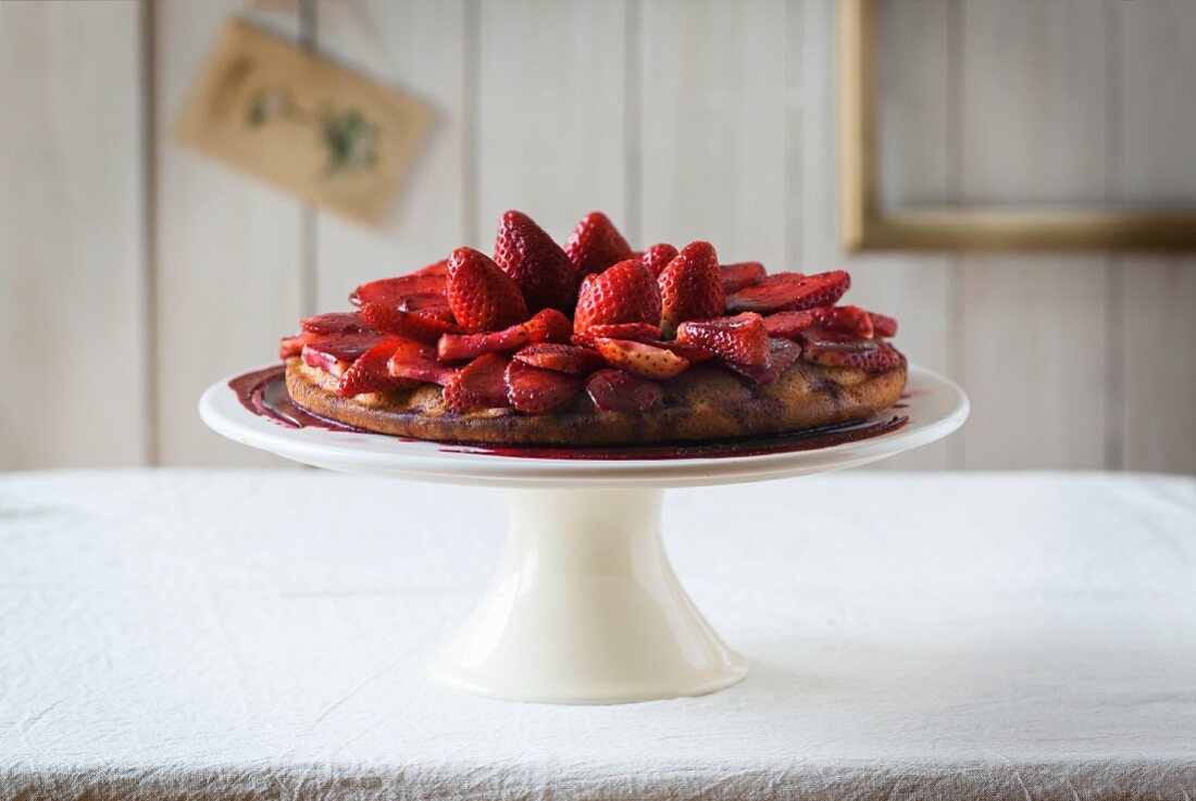 A strawberry cake on a cake stand
