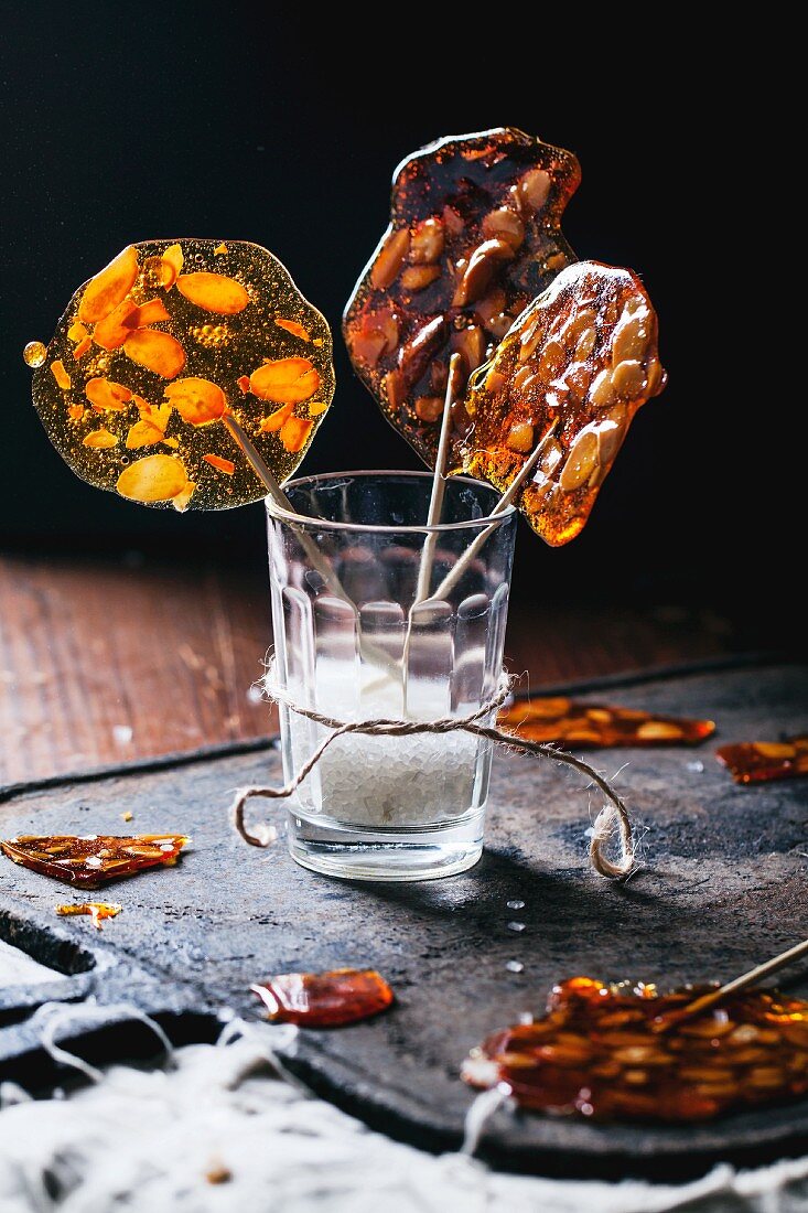 Homemade rock sugar lollies with almonds in a vintage glass