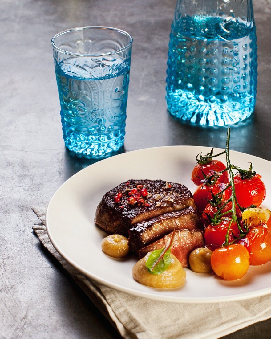 Slice beef steak with pink pepper and steamed cherry tomatoes