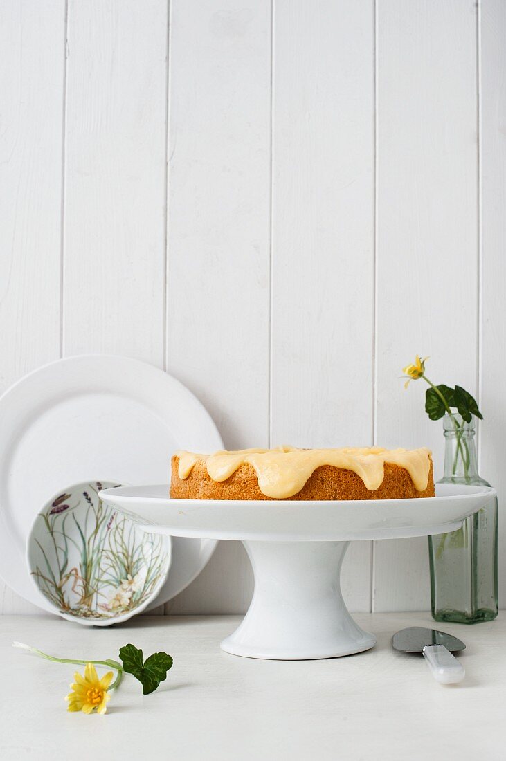 Almond cake with lemon cream on a white cake stand