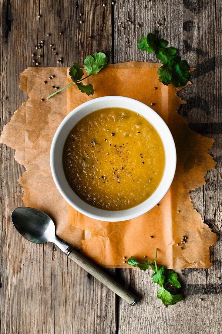 Carrot and coriander soup on a rustic wooden surface