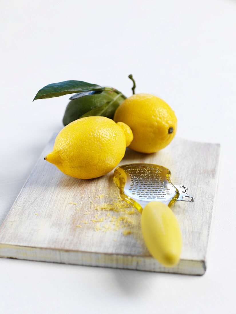 Zitronen und Reibe mit Zitronenzesten