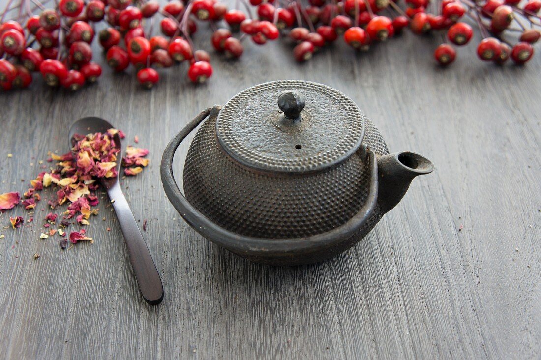 A teapot, rosehips and dried wild rose petals