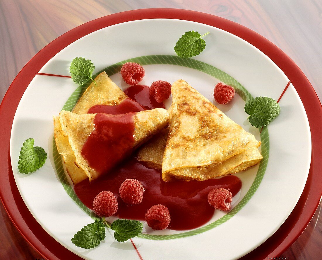 Folded crepes with raspberry sauce