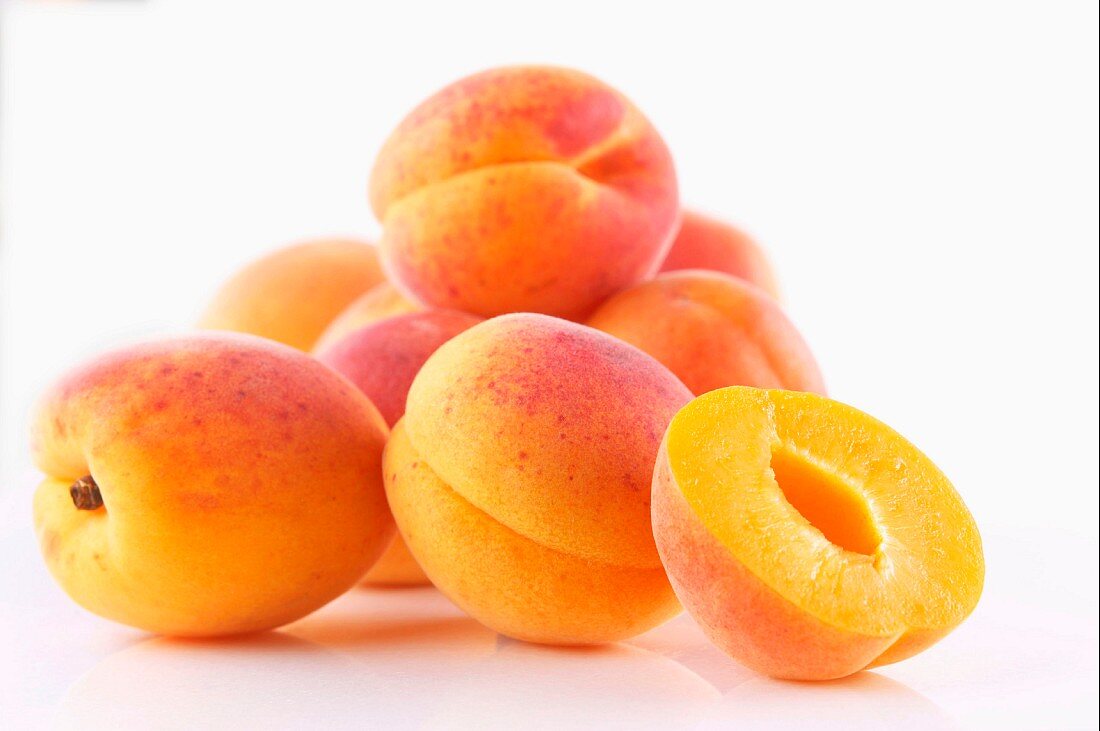 Frische Aprikosen, ganz und halbiert