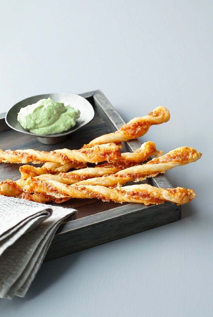 Four cheese sticks on a tray with avocado cream