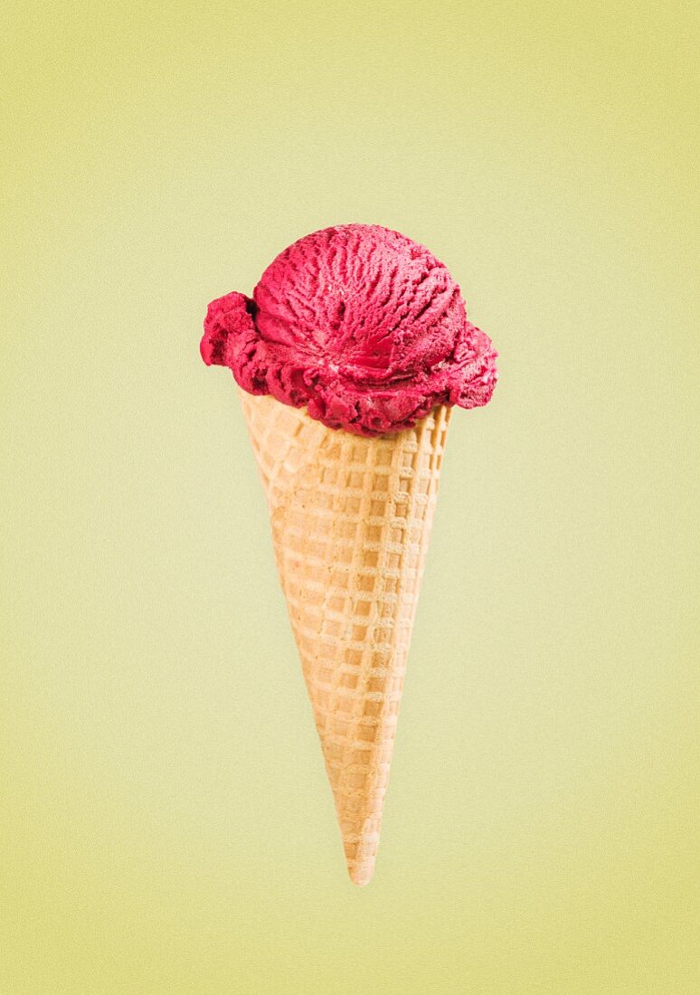 Berry ice cream in a cone against a yellow background