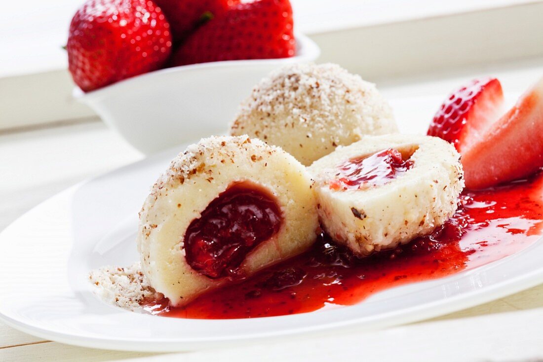 A quark dumpling with a strawberry filling and ground hazelnuts