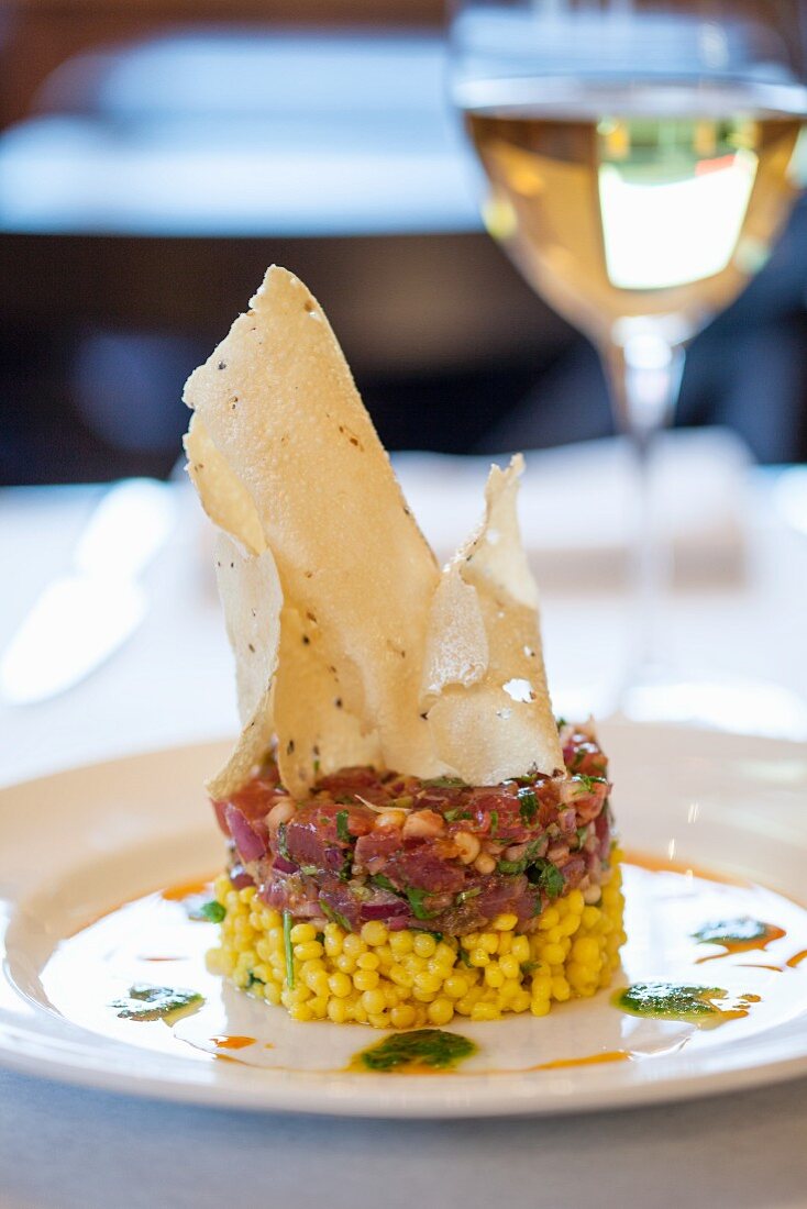 Tuna tartar on a bed of saffron couscous with green olives crispy poppadoms