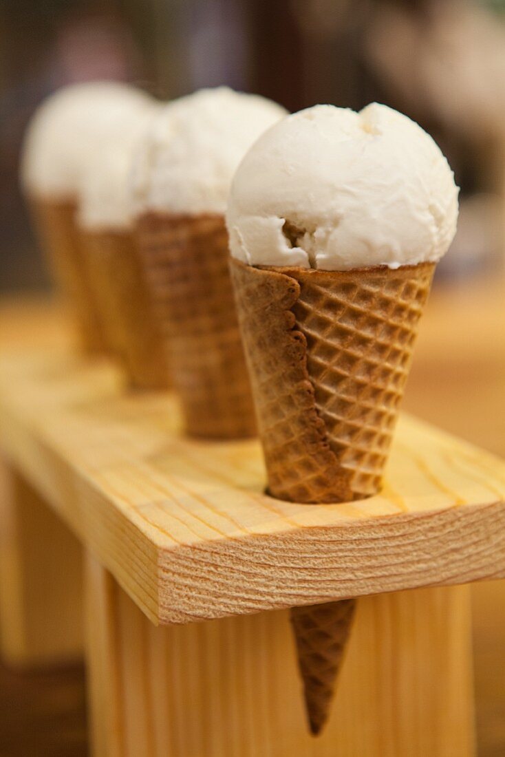 Vanilla ice cream in cones in a cone rack