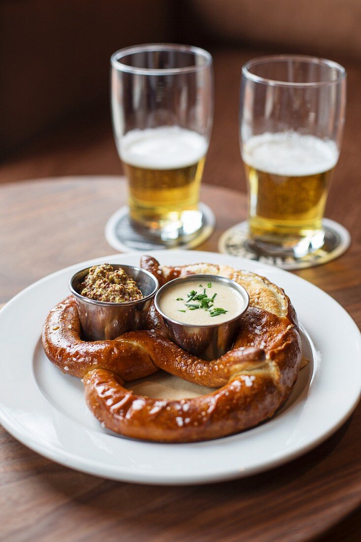 Laugenbrezel mit grobkörnigem Senf und Amish Cheddar-Ale-Sauce