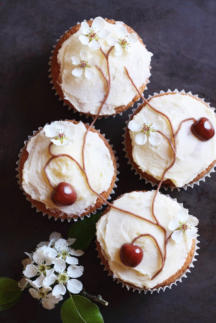 Cupcakes decorated with cherries and cherry blossom arranged to form a tree