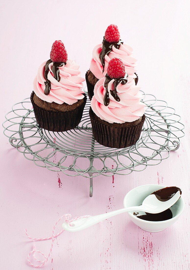 Chocolate cupcakes with raspberry cream and chocolate sauce