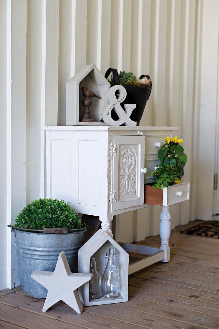 Antique cabinet decorated with potted plants and vintage ornaments