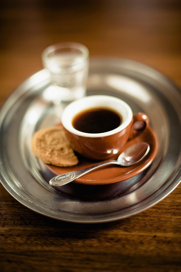 An espresso with a biscuit