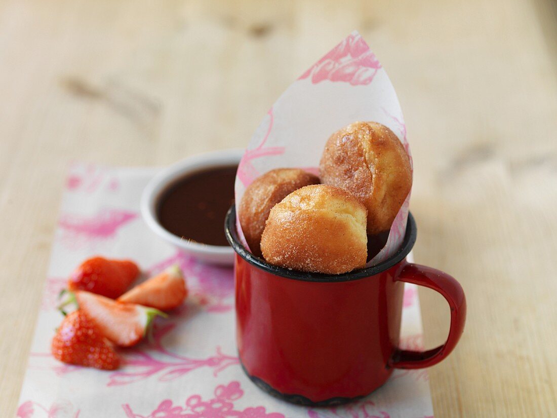 Mini-Doughnuts in einer Tasse, frische Erdbeeren und Schokoladensauce