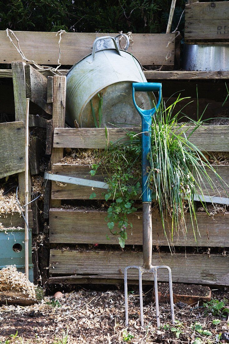 Gardening tools by a compost heap in a garden