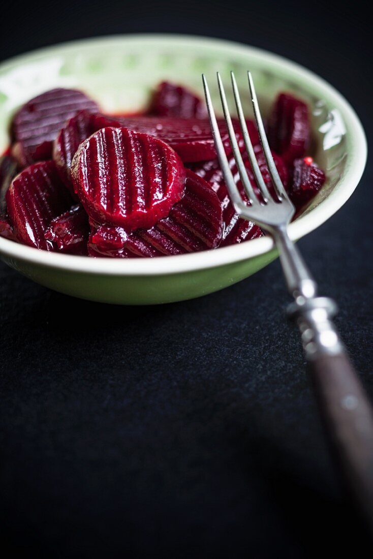 Pickled beetroot in a bowl with a fork
