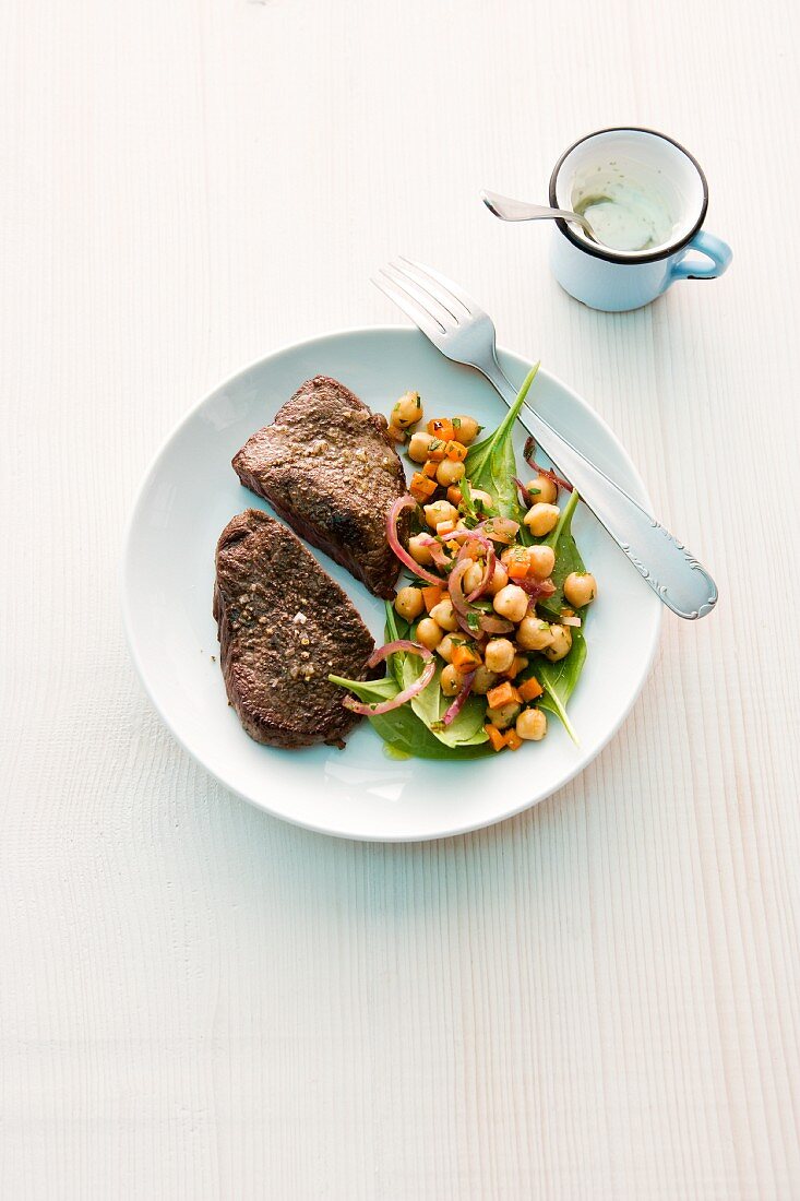 Beef steaks with a chickpea salad (seen from above)