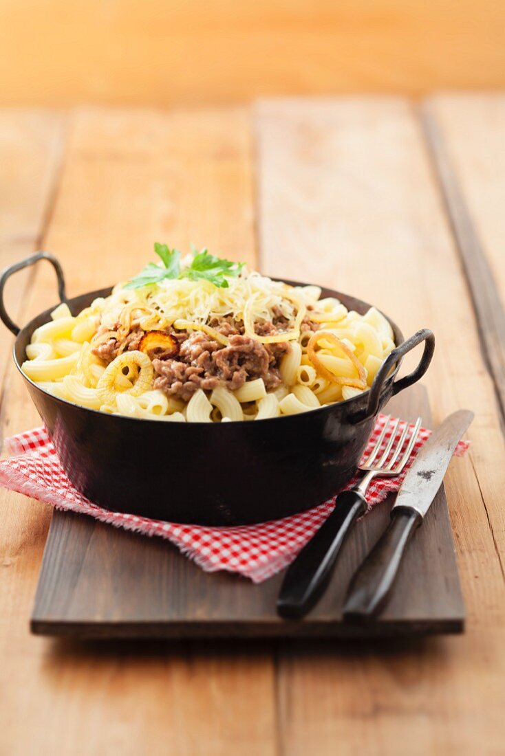 Minced meat with pasta and fried onions in a pan