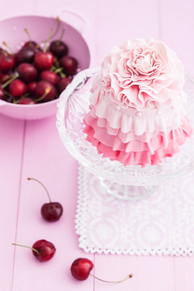 A cherry cake with pink icing