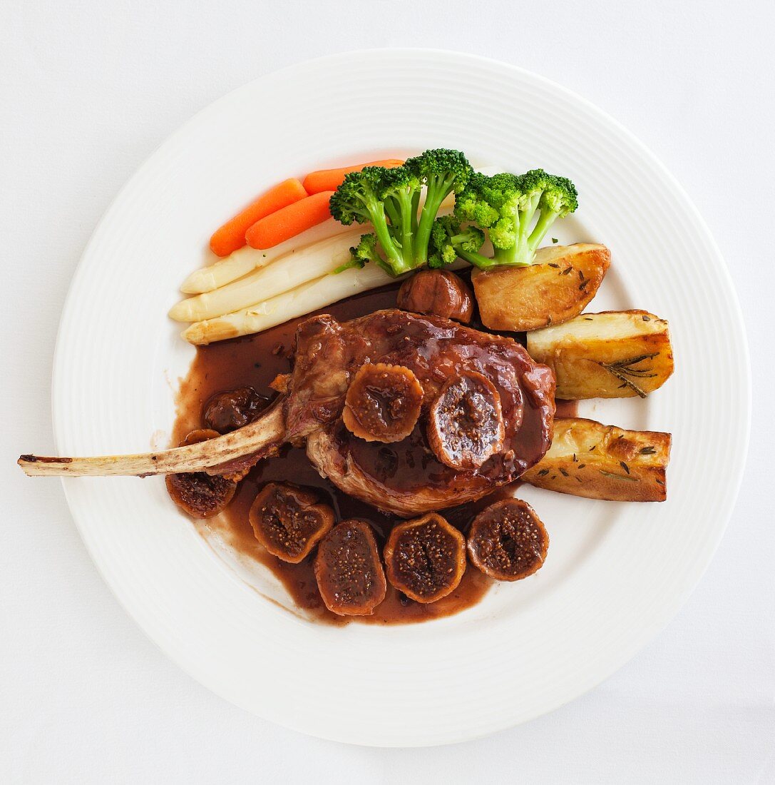 A lamb chop with figs and vegetables