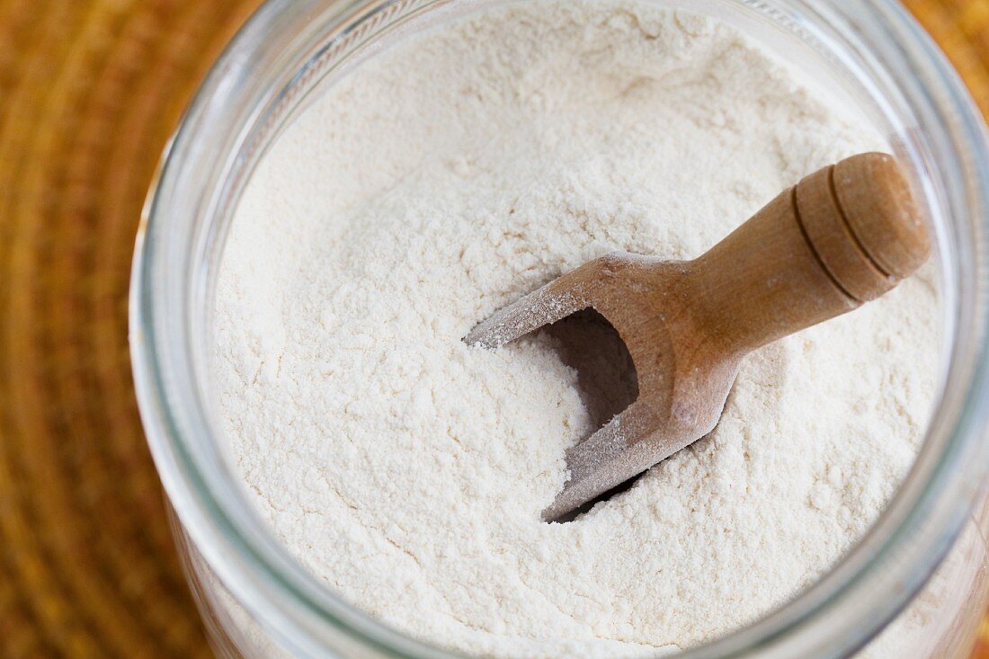 Cassava flour in a storage jar with a scoop