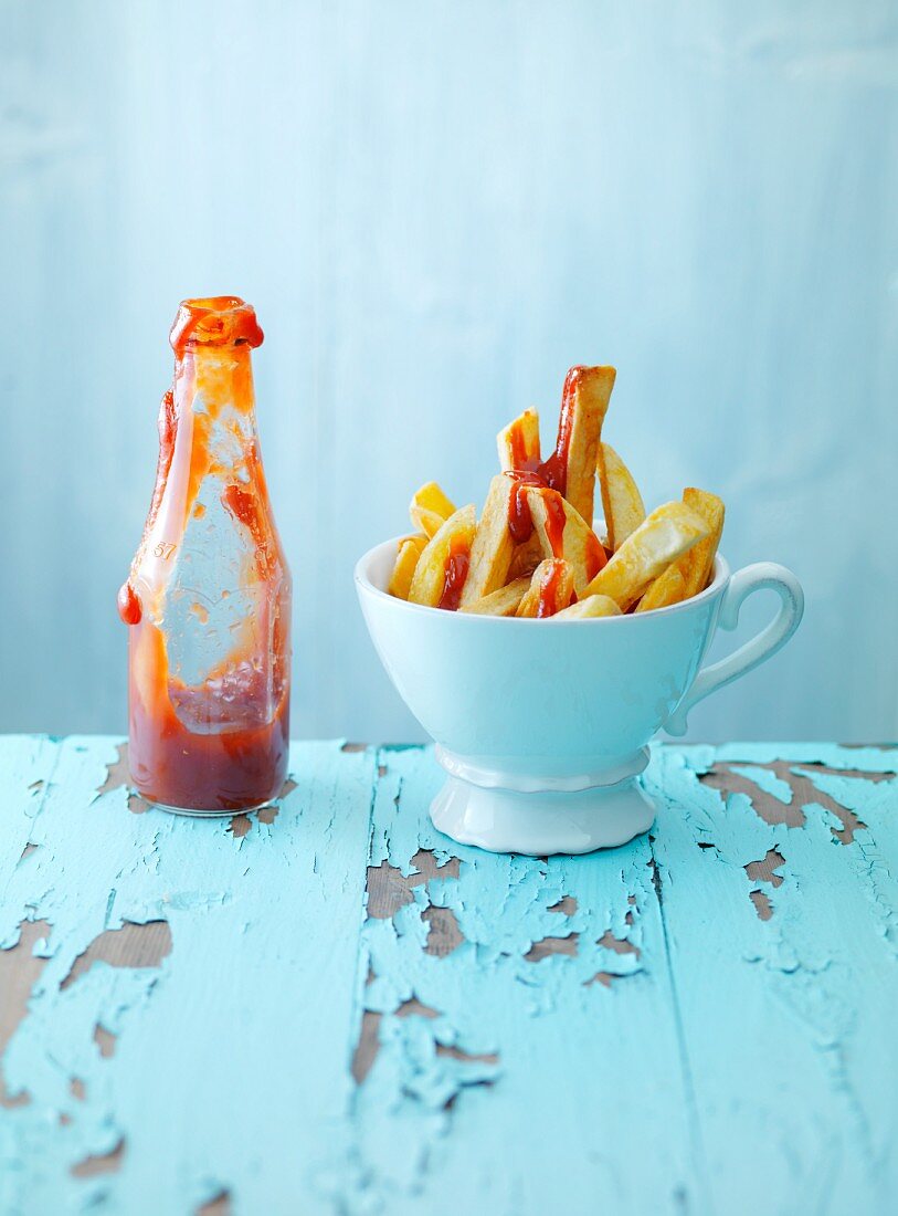 A cup of chips with ketchup