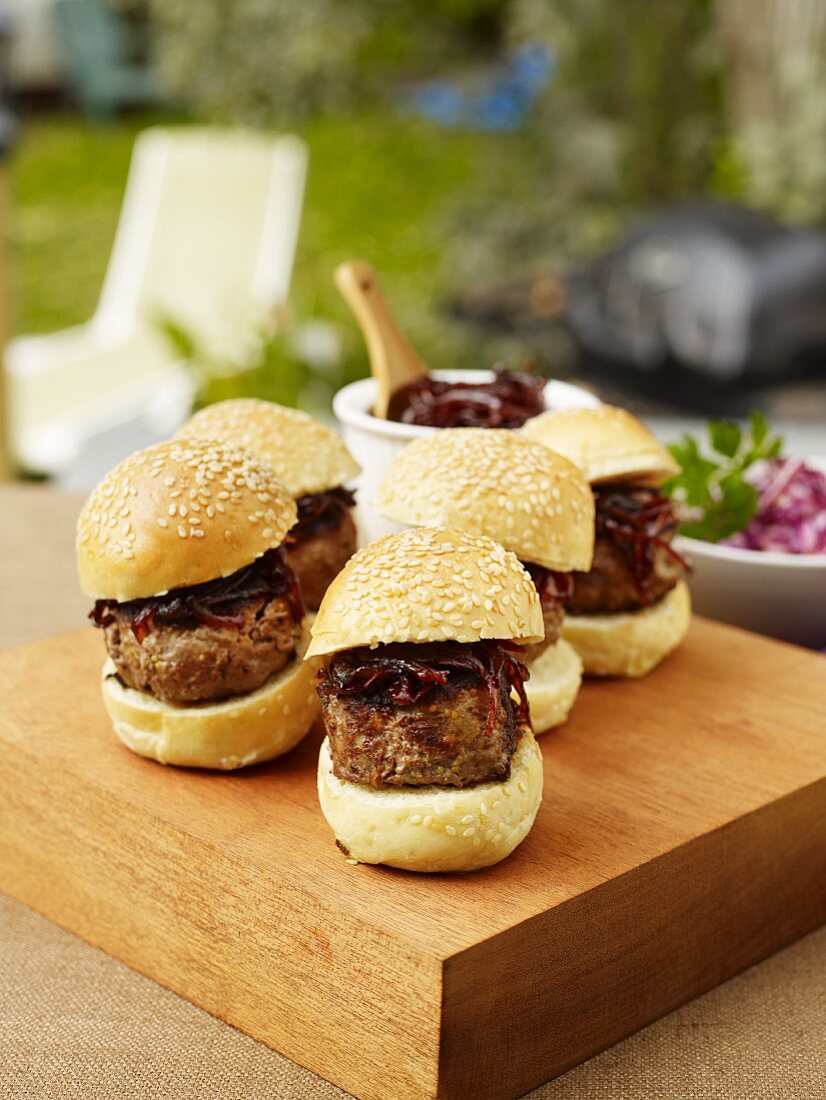 Miniburger mit Zwiebeln auf Gartentisch