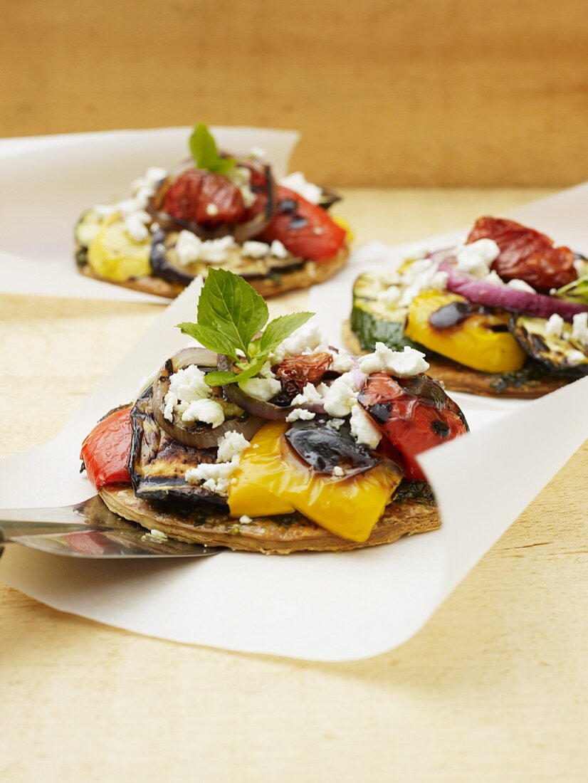 Mini pizzas topped with ratatouille and goat's cheese