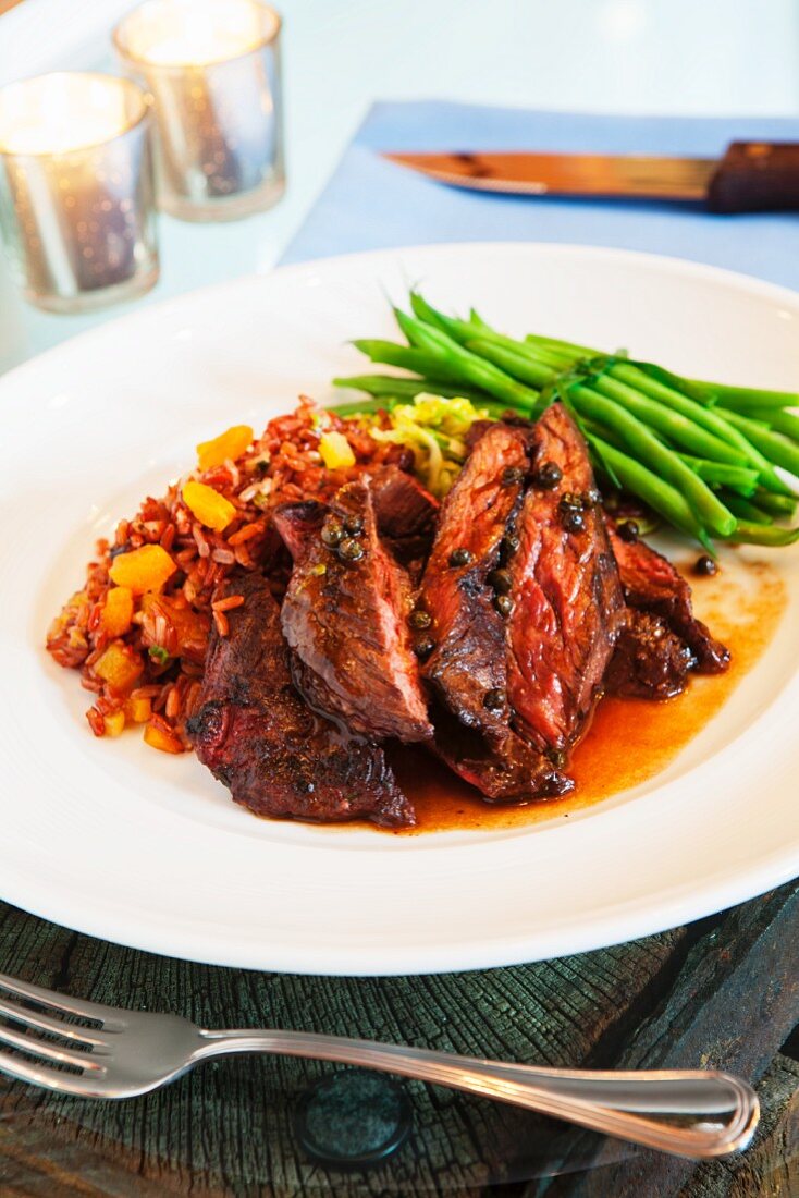 Beef steak with red rice and green beans