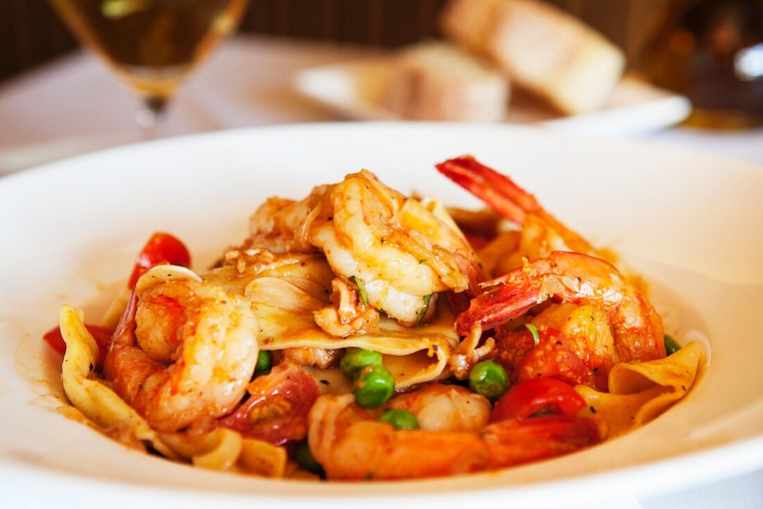 Pasta with fried prawns, tomatoes and peas