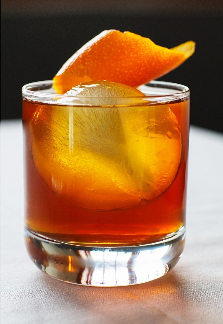 Whiskey mit Orangenschale und Eiswürfel