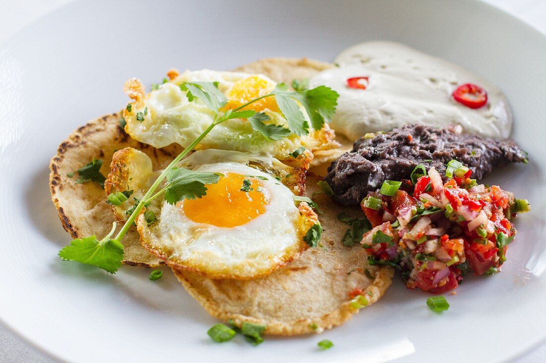 Pancakes with fried eggs and salsa